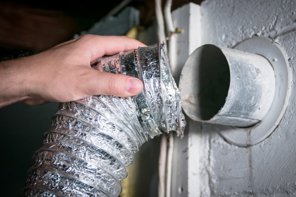Technician cleaning dryer vent with specialized tools